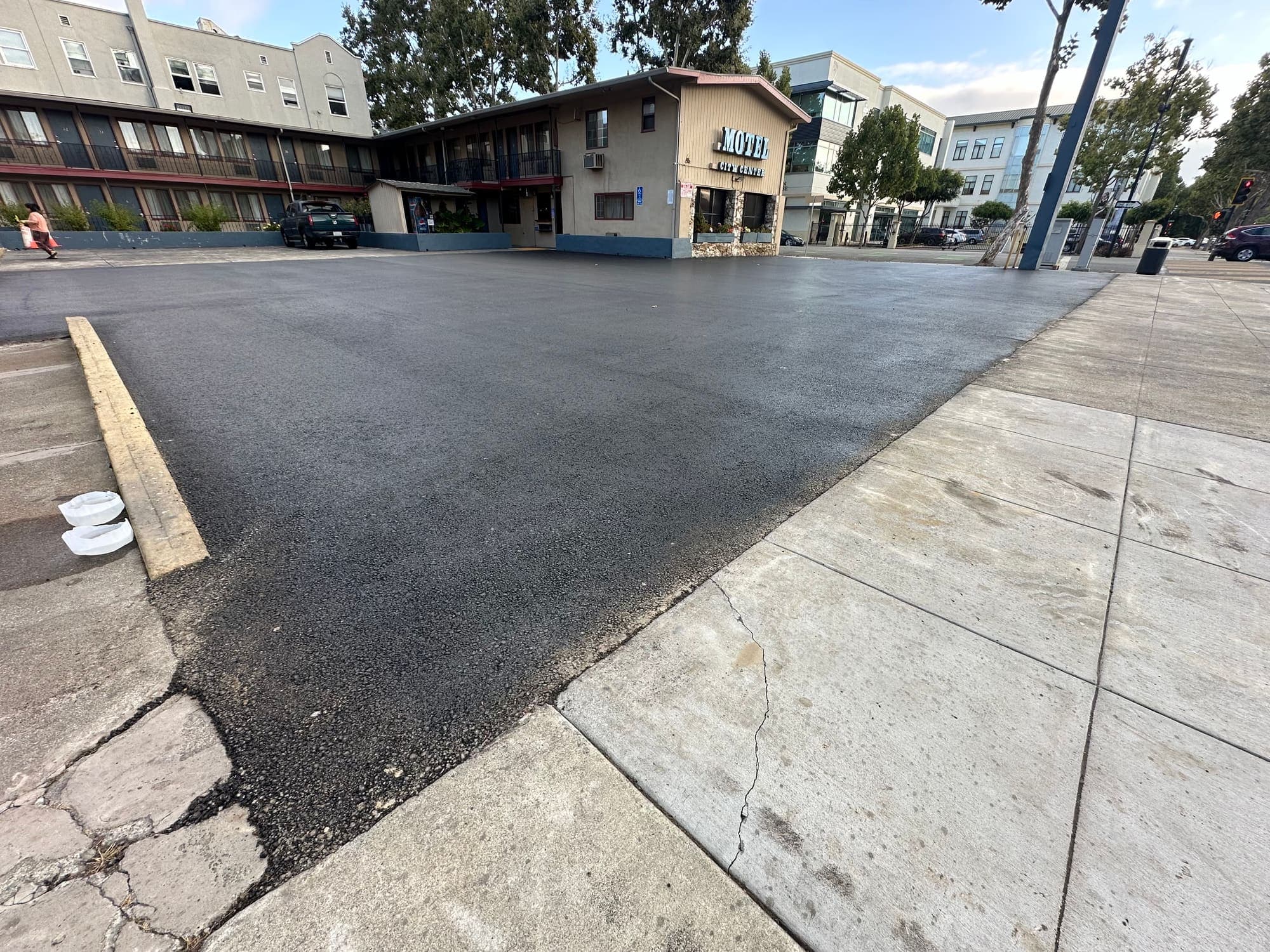Uniform sealed asphalt surface across a downtown commercial parking lot after maintenance