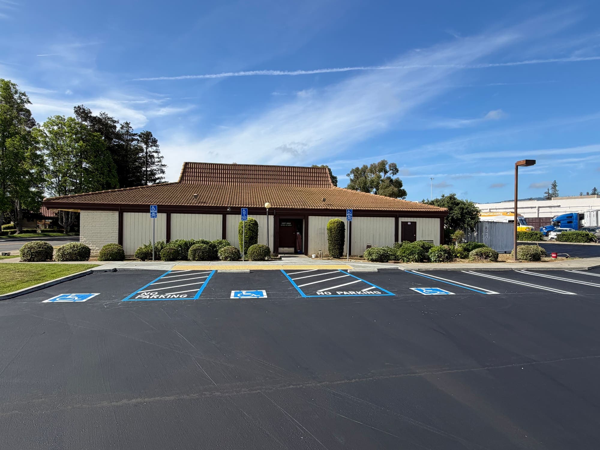 Newly striped ADA accessible parking stalls with blue access aisles and a truncated dome landing pad