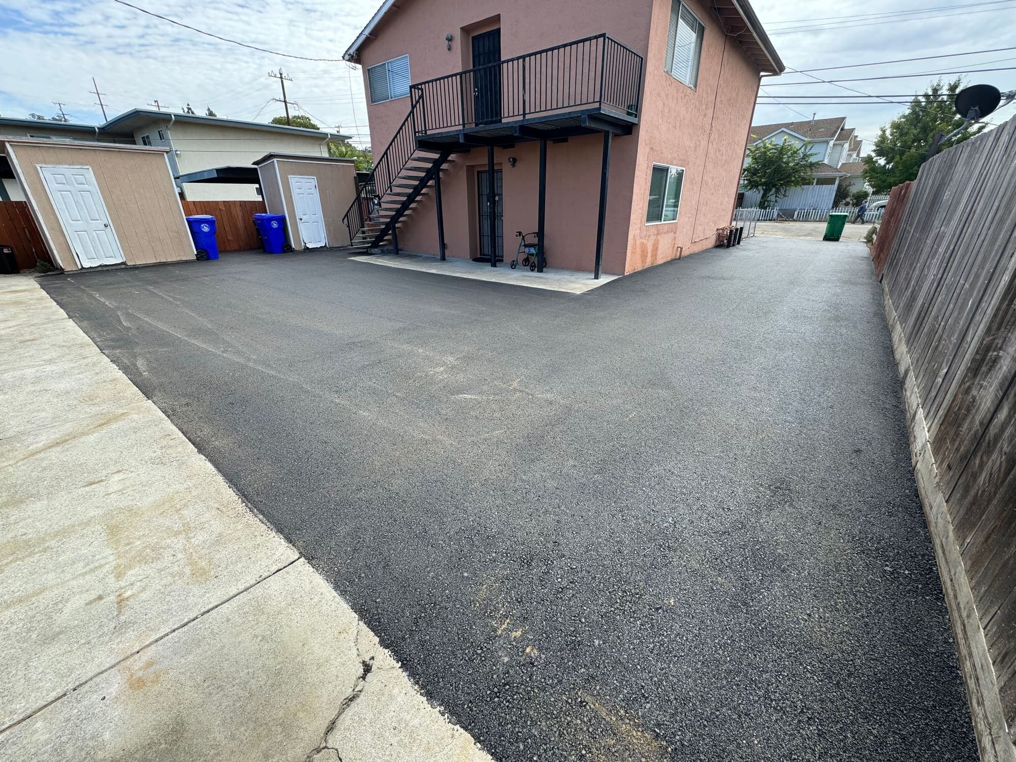 Finished asphalt driveway and parking area at a multifamily property after full-depth replacement